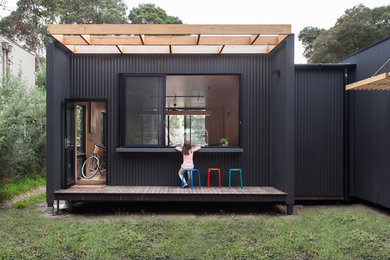 Medium sized and gey contemporary house exterior in Melbourne with metal cladding and a flat roof.