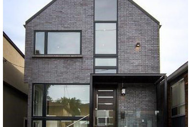 Photo of a medium sized and gey modern two floor brick detached house in Toronto with a pitched roof.