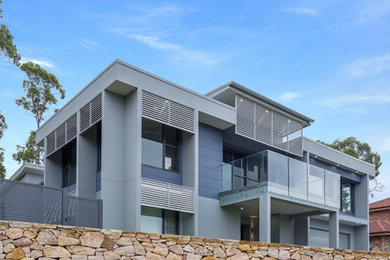 Photo of a blue contemporary split-level house exterior in Sydney with concrete fibreboard cladding.