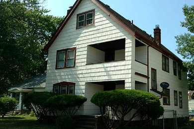 Imagen de fachada de casa blanca tradicional de dos plantas con revestimiento de madera, tejado a dos aguas y tejado de teja de madera
