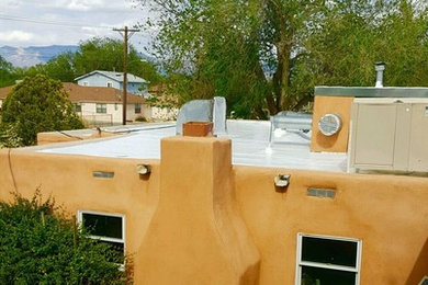 Small transitional one-story adobe flat roof idea in Albuquerque