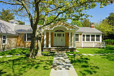 Photo of a medium sized and beige traditional bungalow house exterior in Boston with wood cladding and a hip roof.