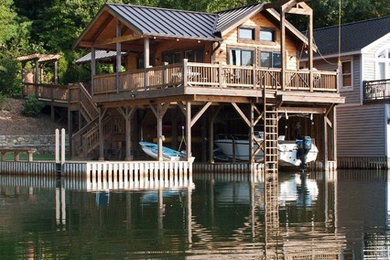 Immagine della facciata di una casa marrone rustica a due piani di medie dimensioni con rivestimento in legno e tetto a capanna