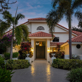 Example of a tuscan white two-story house exterior design in Miami with a hip roof and a tile roof