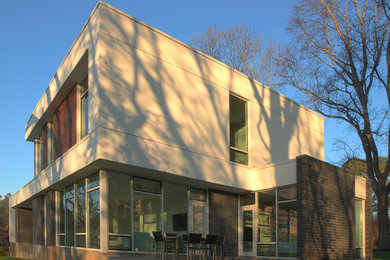 Imagen de fachada de casa blanca minimalista de tamaño medio de dos plantas con tejado plano y revestimiento de estuco