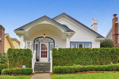 Example of a mid-sized transitional white two-story wood gable roof design in Seattle