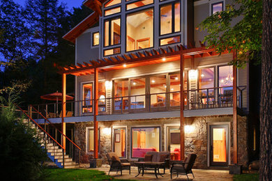 Inspiration pour une façade de maison grise chalet en bois à deux étages et plus.