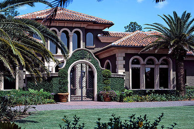 Diseño de fachada de casa verde mediterránea grande de dos plantas con revestimientos combinados, tejado a dos aguas y tejado de teja de barro