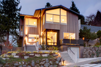 Inspiration for a large and brown contemporary house exterior in Seattle with three floors, wood cladding and a pitched roof.