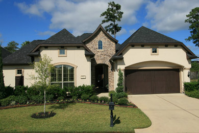 Mid-sized mediterranean beige two-story stucco exterior home idea in Houston with a hip roof