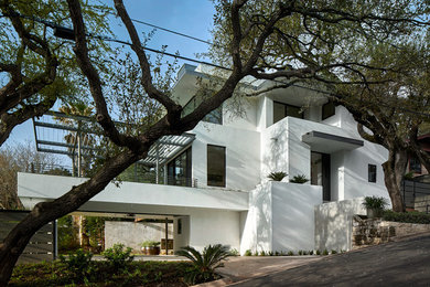 Medium sized and white contemporary render house exterior in Austin with three floors and a flat roof.