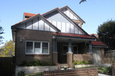 Modelo de fachada de casa clásica de tamaño medio de dos plantas con revestimiento de ladrillo, tejado a dos aguas y tejado de teja de barro