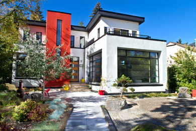 Imagen de fachada blanca minimalista de tamaño medio de dos plantas con revestimiento de estuco y tejado plano