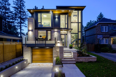 Idée de décoration pour une façade de maison design à deux étages et plus avec un revêtement mixte.
