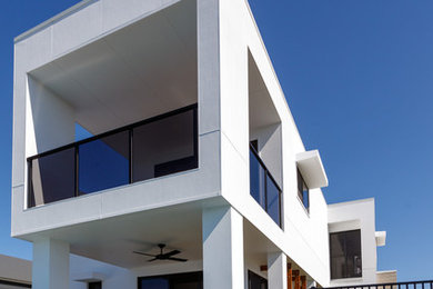 Ejemplo de fachada de casa blanca actual de tamaño medio de dos plantas con revestimiento de hormigón, tejado plano y tejado de metal