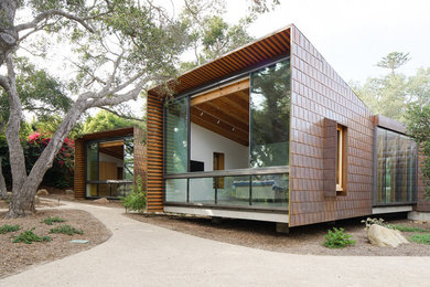 Inspiration for a huge contemporary brown one-story metal house exterior remodel in Los Angeles with a shingle roof and a shed roof
