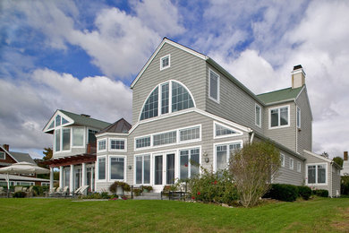 Example of a beach style gray wood house exterior design in Bridgeport with a shed roof and a shingle roof