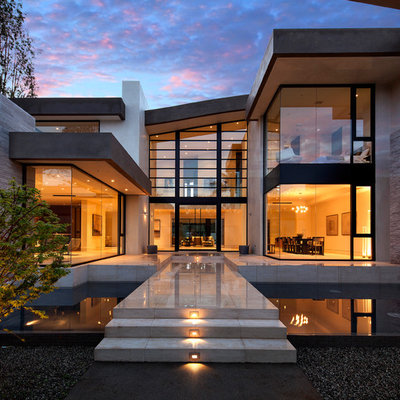 Large contemporary beige two-story glass house exterior idea in Los Angeles