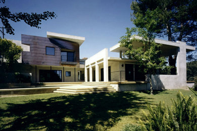 Imagen de fachada de casa gris contemporánea de tamaño medio de dos plantas con revestimiento de metal, tejado plano y tejado de varios materiales