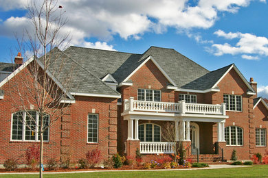 Photo of an expansive and red traditional two floor brick house exterior in Providence with a hip roof.