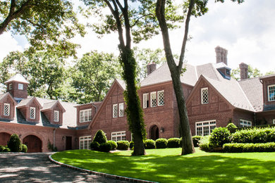 Example of a large classic red two-story brick exterior home design in Other with a shingle roof