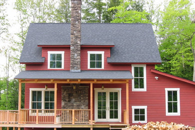 Example of a farmhouse red two-story exterior home design in Portland Maine