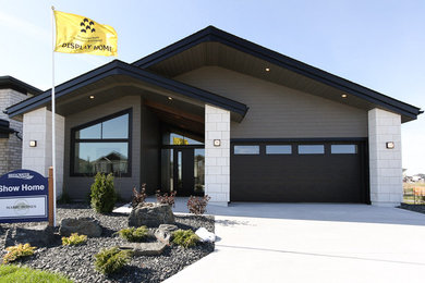 Large trendy gray one-story concrete fiberboard exterior home photo in Other with a shingle roof