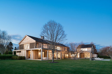 Example of a huge trendy two-story wood exterior home design in New York
