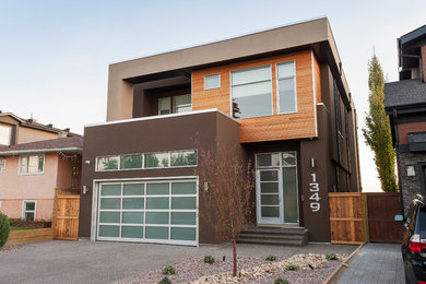 Modern brown two-story stucco flat roof idea in Calgary