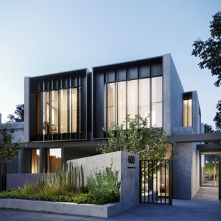 Large contemporary three-storey stucco grey townhouse exterior in Melbourne with a flat roof and a metal roof.