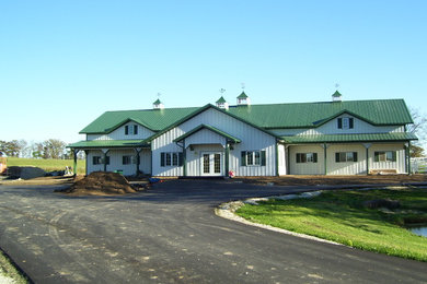 Imagen de fachada verde moderna grande de dos plantas con revestimiento de metal y tejado a dos aguas