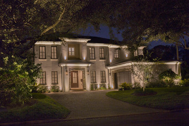 Large traditional beige two-story stucco house exterior idea in Tampa with a hip roof and a shingle roof