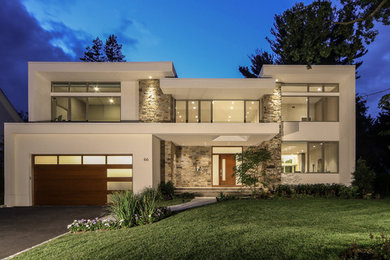Diseño de fachada de casa blanca minimalista grande de dos plantas con revestimiento de estuco y tejado plano