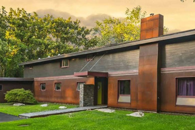 Diseño de fachada de casa multicolor minimalista de tamaño medio de dos plantas con revestimiento de metal, tejado a dos aguas y tejado de metal