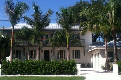 Modelo de fachada blanca exótica grande de dos plantas con revestimiento de estuco y tejado a doble faldón