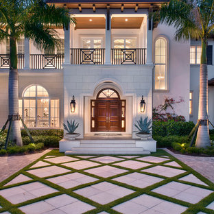 Huge tropical beige two-story mixed siding exterior home idea in Miami