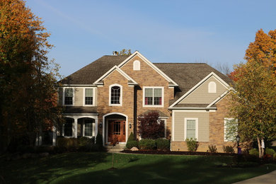 Mid-sized elegant beige two-story stone exterior home photo in Cleveland with a hip roof and a shingle roof