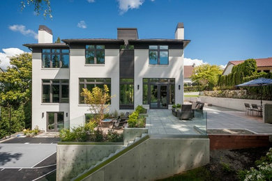 Inspiration for a large modern white three-story stucco exterior home remodel in Seattle with a hip roof