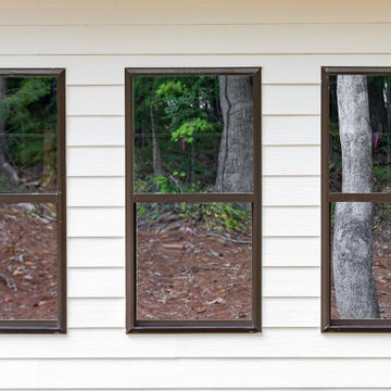 Bronze windows complement the white siding