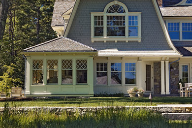 Cette photo montre une façade de maison grise victorienne en bois à un étage avec un toit de Gambrel.