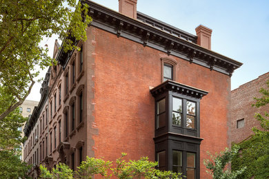 Imagen de fachada marrón de tres plantas con revestimientos combinados