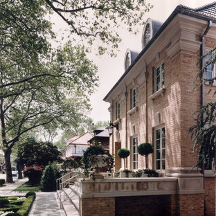 Foto på ett stort vintage rött hus, med tre eller fler plan, tegel och valmat tak