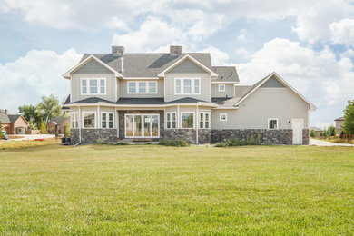 Large and gey country two floor house exterior in Denver with wood cladding and a pitched roof.