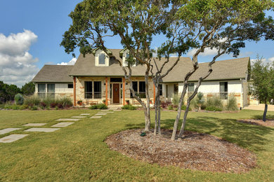 Inspiration for a large timeless beige one-story mixed siding gable roof remodel in Austin