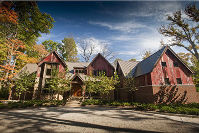 На фото: большой, двухэтажный, коричневый дом в стиле фьюжн с комбинированной облицовкой и двускатной крышей с