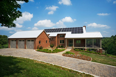 Transitional two-story brick exterior home photo in Other with a metal roof