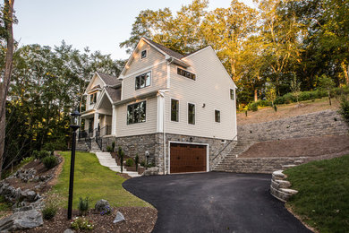 Large elegant beige three-story concrete fiberboard exterior home photo in Philadelphia with a shingle roof