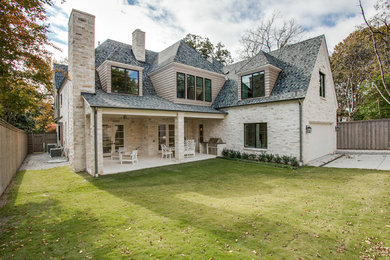 Foto de fachada de casa beige clásica de tamaño medio de dos plantas con revestimientos combinados, tejado a dos aguas y tejado de teja de madera