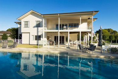Inspiration for a large and white classic two floor house exterior in Sunshine Coast with wood cladding.