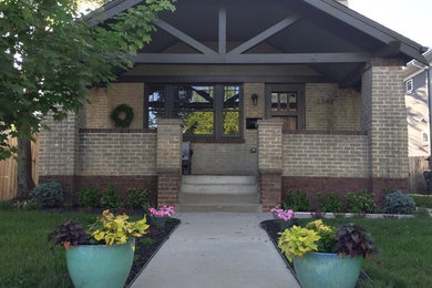 Ejemplo de fachada de casa beige de estilo americano de una planta con revestimiento de ladrillo